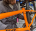 a bike mechanic adjusting the barrel adjuster on a rear derailleur