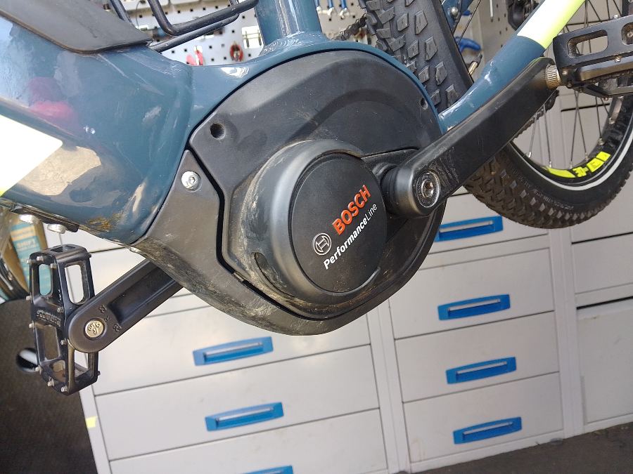 Bosch Performance Line mid-drive e-bike motor casing and crank arm mounted on a bicycle frame